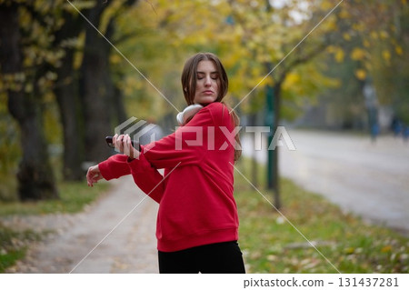Athletic young woman taking a breath and relaxing after jogging and stretching. Woman Training and Workout Exercises On Street. Athletic young woman taking a breath and relaxing after jogging and stretching. Woman Training and Workout Exercises On Street. 131437281