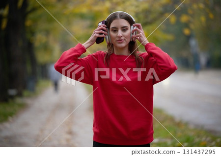 Athletic young woman taking a breath and relaxing after jogging and stretching. Woman Training and Workout Exercises On Street. 131437295
