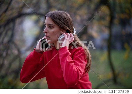 Athletic young woman taking a breath and relaxing after jogging and stretching. Woman Training and Workout Exercises On Street. 131437299