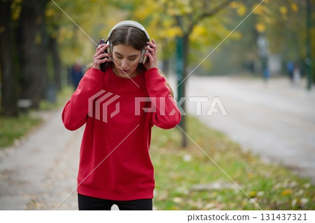 Athletic young woman taking a breath and relaxing after jogging and stretching. Woman Training and Workout Exercises On Street. 131437321