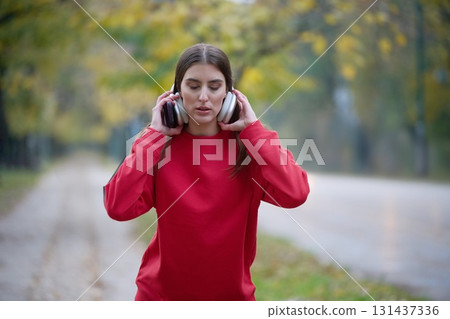 Athletic young woman taking a breath and relaxing after jogging and stretching. Woman Training and Workout Exercises On Street. 131437336