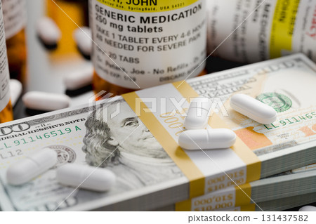 Prescription Medicine Bottles and Pills Next To Stacks of 100 Dollar Bills. Prescription Medicine Bottles and Pills Next To Stacks of 100 Dollar Bills. 131437582