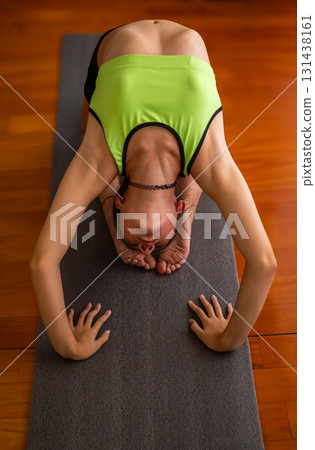 Teenager stretching surrounded by natural light, ideal for wellness projects. 131438161