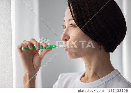 中年婦女在窗邊刷牙 131438196