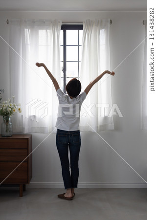 一位女士在窗邊伸展身體的背影 131438282