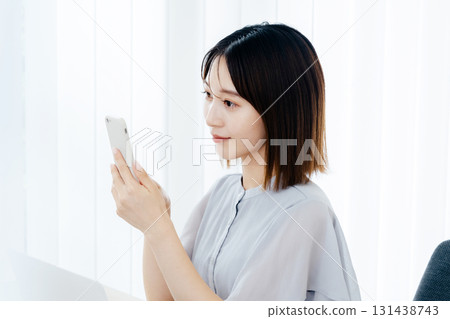 在辦公室看智能手機的女商人 131438743