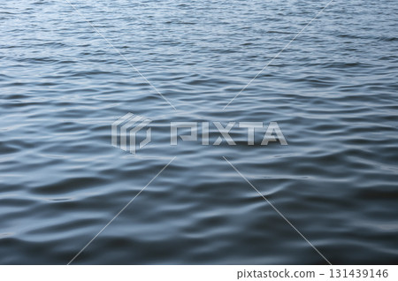 An abstract view of water surface waving by the wind. Wind-driven waves, or surface waves, are created by the friction between wind and surface water. An abstract view of water surface waving by the wind. Wind-driven waves, or surface waves, are created by the friction between wind and surface water. 131439146