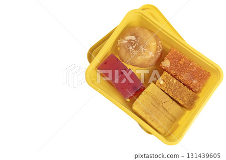 Various types of Indian sweets in a yellow box on a white background. Various types of Indian sweets in a yellow box on a white background. 131439605