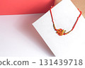 Traditional Indian Rakhi bangle with red string and decorative motif 131439718