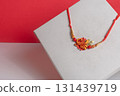 Traditional decorative thread rakhi with brightly colored beads and floral designs for Raksha Bandhan. 131439719