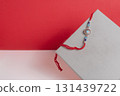 Elegant Rakhi bangle displayed on a modern paper background in red and white 131439722