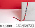 Elegant red thread rakhi with gemstone beads on a modern background 131439723