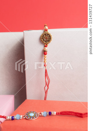Elegant red beaded bracelet with an ornate gold pendant displayed in a gift box for a special occasion gift. 131439727
