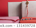 Festive gift boxes with beaded rakhi bangles on a red background - decorative gift arrangement 131439728
