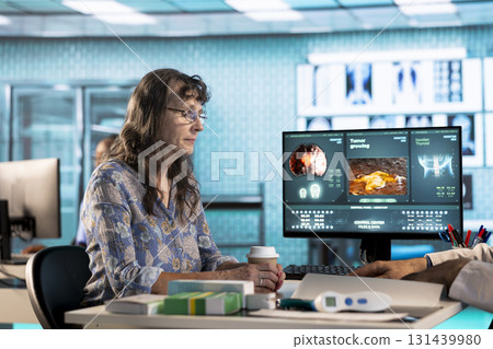 General practitioner consults senior female patient about diagnostic test results, utilizing medical technology for accurate report and care management in a clinic. Healthcare provider. 131439980