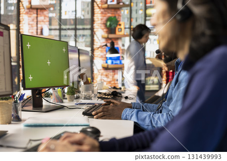 Call center agent using isolated screen PC, handling customer inquiries, complaints and support requests in office. Customer service worker using chroma key computer, assisting customers with issues 131439993