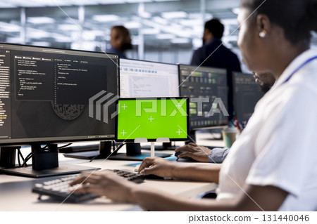 System administrator using green screen tablet to check for signs of failure in data center. African american woman working on mockup device to prevent damages in server farm, monitoring systems 131440046