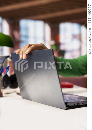 Remote employee at home office desk opening laptop lid to compose social media posts, producing content. Close up of remote worker starting job shift in the morning, monitoring social media engagement 131440067