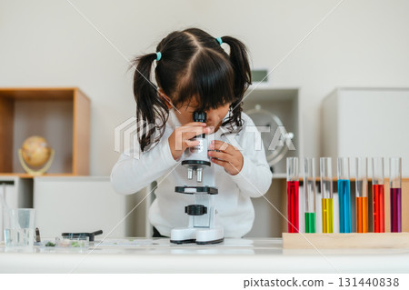 toddler girl scientist looking through microscope. learning science 131440838