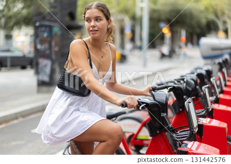 Young woman renting a bicycle 131442576