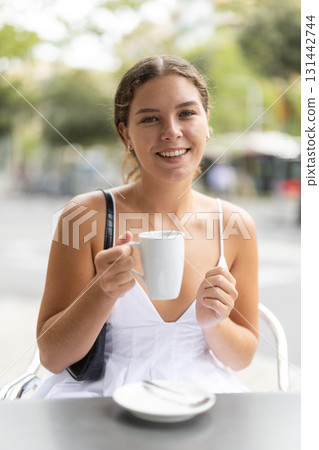 Young woman sitting in cafe and drinking tea Young woman sitting in cafe and drinking tea 131442744