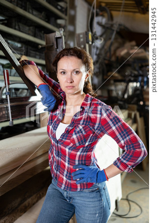 Adult woman posing in oak workshop 131442945