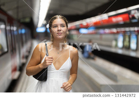 Young girl standing on platform of underground station 131442972
