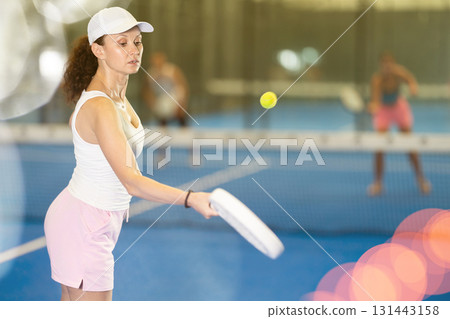 Adult woman playing tennis against man and woman 131443158