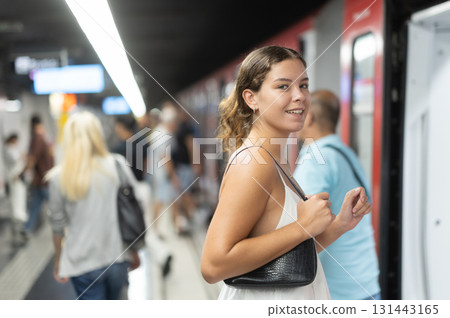 Young woman standing on platform waiting for train 131443165