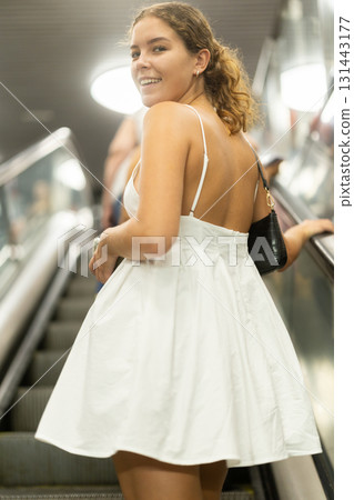 Young girl going up on moving staircase 131443177