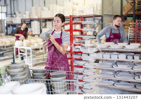 Young woman posing with ceramic dishes 131443207