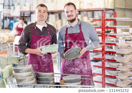 Two men posing with ceramic dishes Two men posing with ceramic dishes 131443232