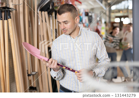 Amateur gardener man selects necessary items tools for her hobby in greenhouse flower-bed Amateur gardener man selects necessary items tools for her hobby in greenhouse flower-bed 131443279