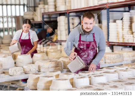Young man pouring clay into mold 131443313