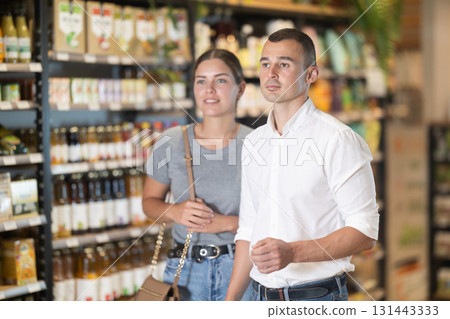 Married couple stands in middle of hall and looks at something in distance of trading floor Married couple stands in middle of hall and looks at something in distance of trading floor 131443333