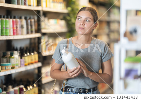 Girl choosing organic cosmetics in eco-friendly produce store Girl choosing organic cosmetics in eco-friendly produce store 131443418