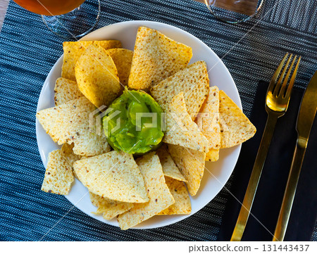 Corn chips with guacamole sauce. Corn chips with guacamole sauce. 131443437