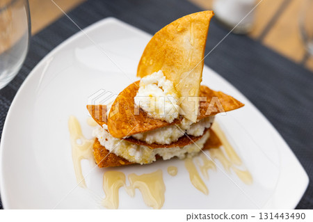 Mato served with honey and biscuits on plate 131443490