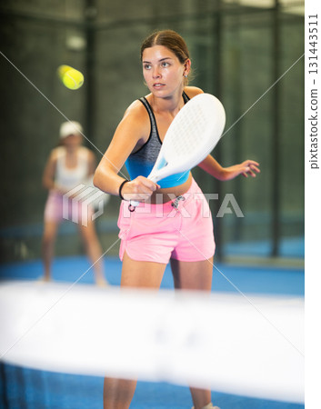 Young and adult women playing doubles tennis Young and adult women playing doubles tennis 131443511