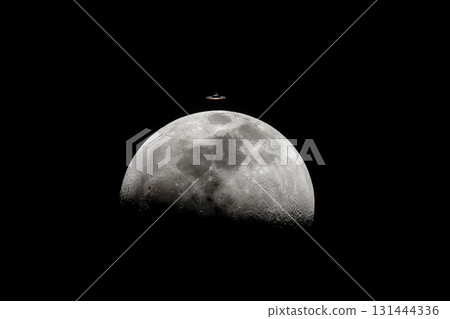 Moon rising above dark sky with an unusual object hovering close 131444336