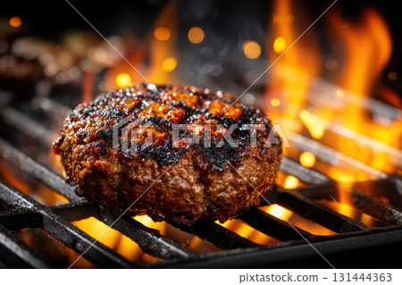Juicy grilled beef patty sizzling over open flames at summer barbecue 131444363
