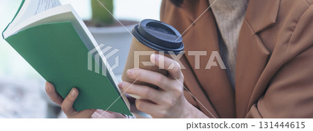 Banner hands of woman sitting office desk holding sweet coffee cup relax and enjoy with happy time. Panorama Hot coffee mug. Woman holding coffee cup relaxing after work at office in cafe copy space 131444615