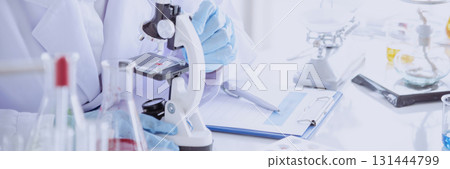 Banner Asian woman scientist hand write note research in medical lab look at science microscope. Panorama biology chemistry lab. Asian Female technician laboratory using microscope with copy space Banner Asian woman scientist hand write note research in medical lab look at science microscope. Panorama biology chemistry lab. Asian Female technician laboratory using microscope with copy space 131444799