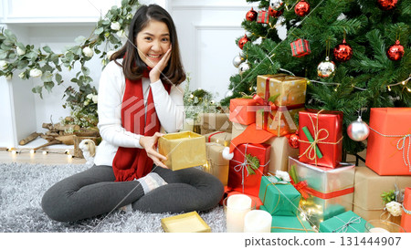 Asian Woman unwrap christmas gift box under xmas tree got surprise present gift. Asian women unbox gift box sitting under decor bauble ball christmas tree xmas holiday winter celebrate in living room Asian Woman unwrap christmas gift box under xmas tree got surprise present gift. Asian women unbox gift box sitting under decor bauble ball christmas tree xmas holiday winter celebrate in living room 131444907