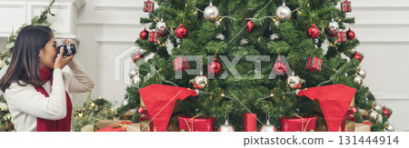 Banner Woman surprise got present gift box on christmas eve. Asian woman holding christmas gift box under xmas tree with smiling face. Happiness Women hands show gift. Merry christmas with copy space 131444914