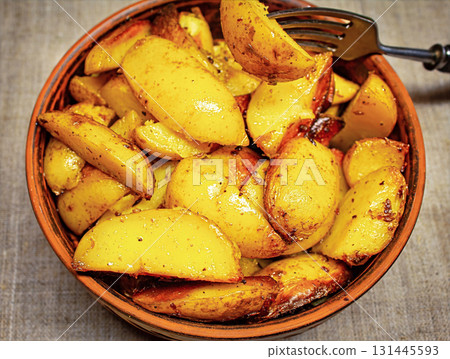 Fried potatoes in a bowl with a fork 131445593