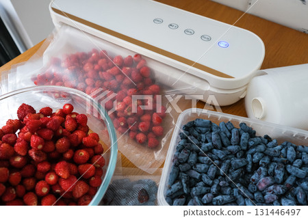 Vacuum sealer of strawberries, honeysuckle in bag, packaging for long-term storage . Vacuum packing machine Vacuum sealer of strawberries, honeysuckle in bag, packaging for long-term storage . Vacuum packing machine 131446497