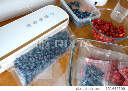 Vacuum sealer of strawberries, honeysuckle in bag, packaging for long-term storage . Vacuum packing machine 131446500