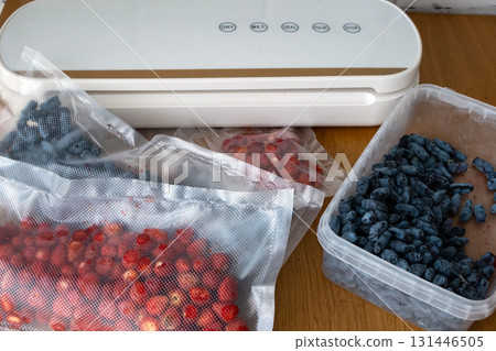 Vacuum sealer of strawberries, honeysuckle in bag, packaging for long-term storage . Vacuum packing machine Vacuum sealer of strawberries, honeysuckle in bag, packaging for long-term storage . Vacuum packing machine 131446505