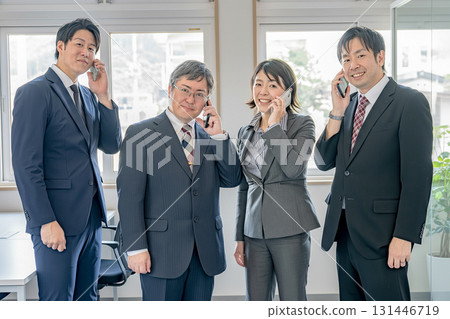 Smiling business team making phone calls Smiling business team making phone calls 131446719